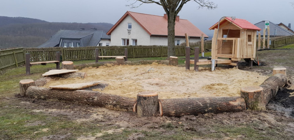Sandkasteneinfassung aus Natur-Baumstämmen