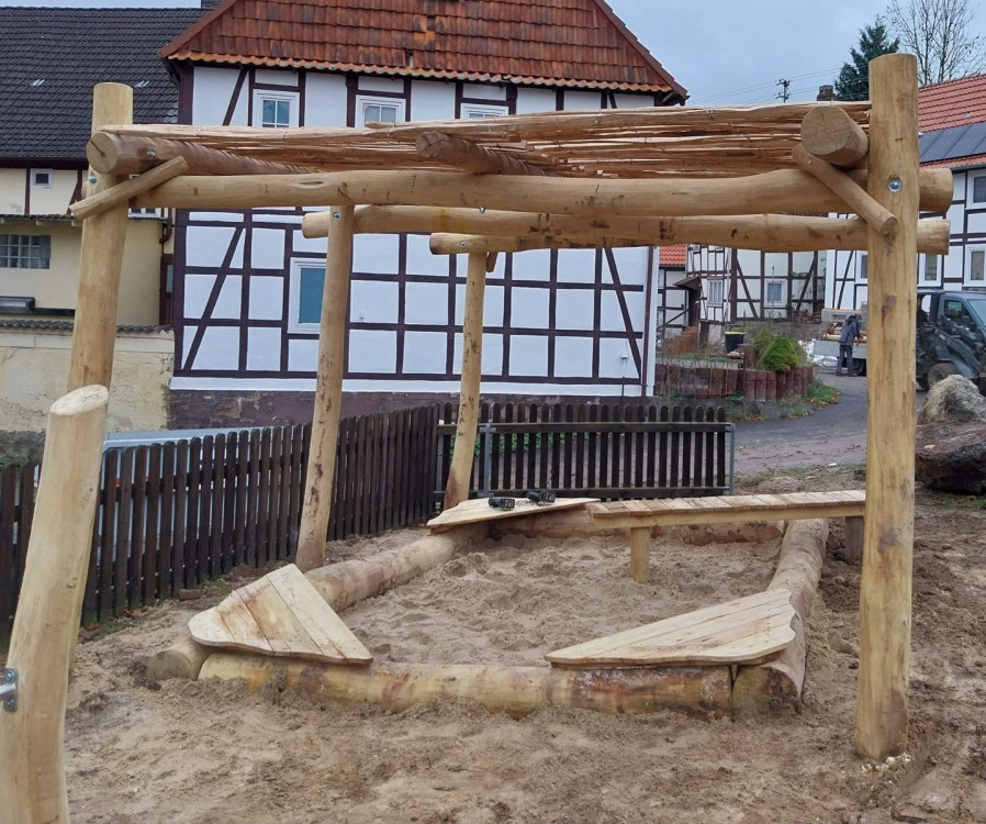 Sandkasteneinfassung aus Robinien-Baumstämmen